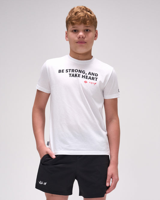 Person wearing a white t-shirt with text and black shorts on a light gray background