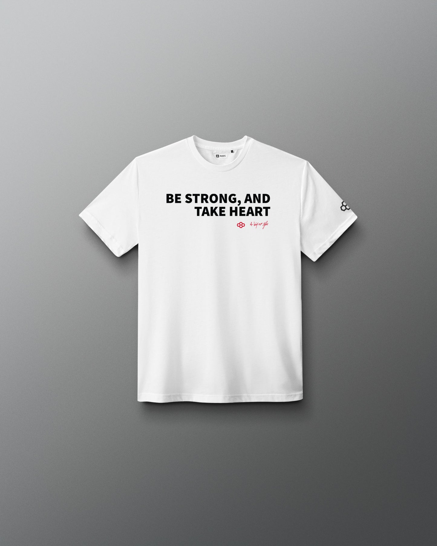 White t-shirt with text 'BE STRONG, AND TAKE HEART' on a gray background