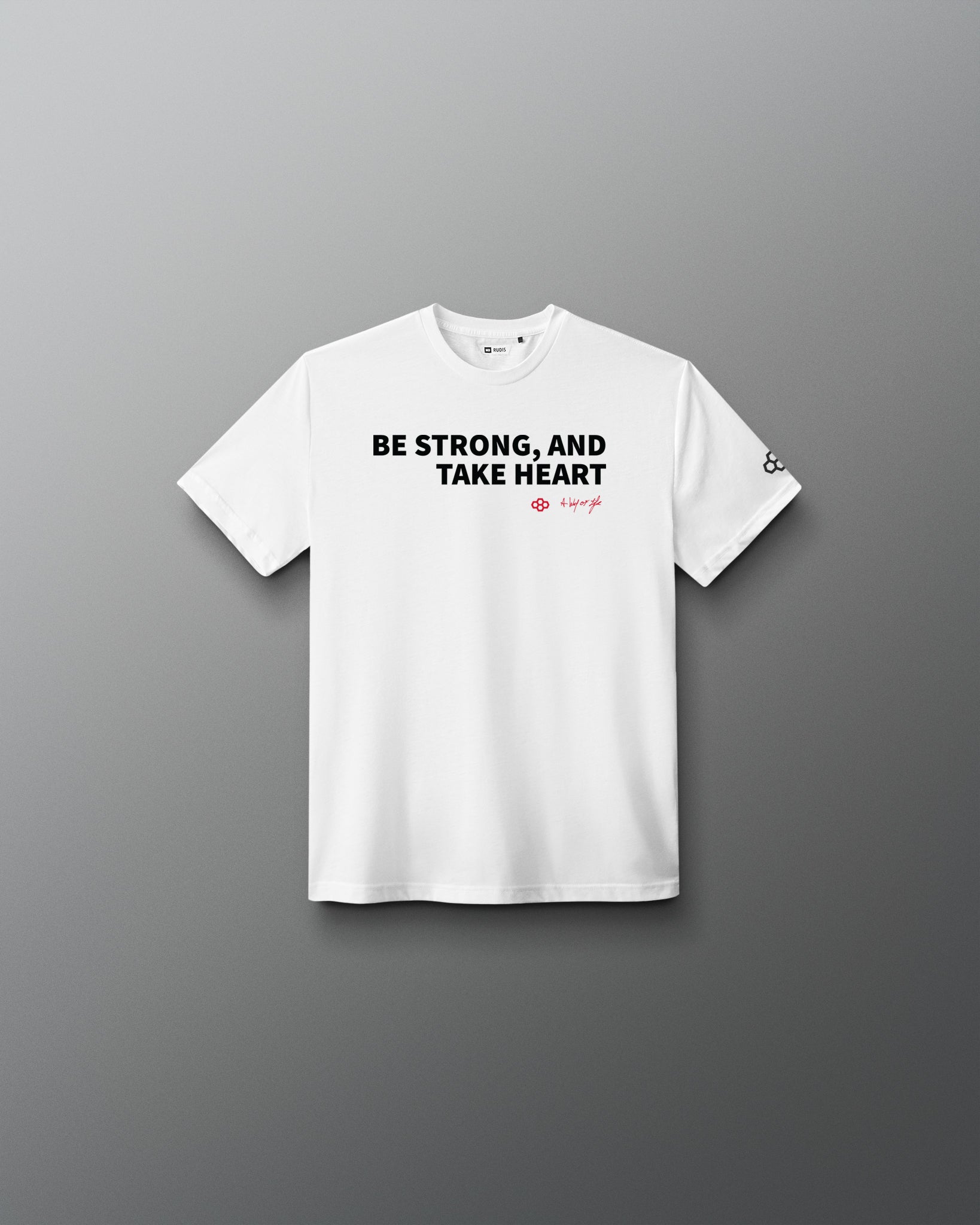 White t-shirt with text 'BE STRONG, AND TAKE HEART' on a gray background