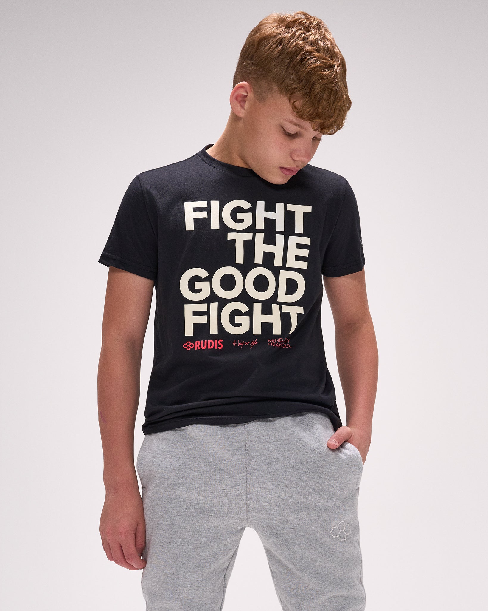 Youth athlete wearing RUDIS black “Fight The Good Fight” t-shirt with bold wrestling-inspired front graphic