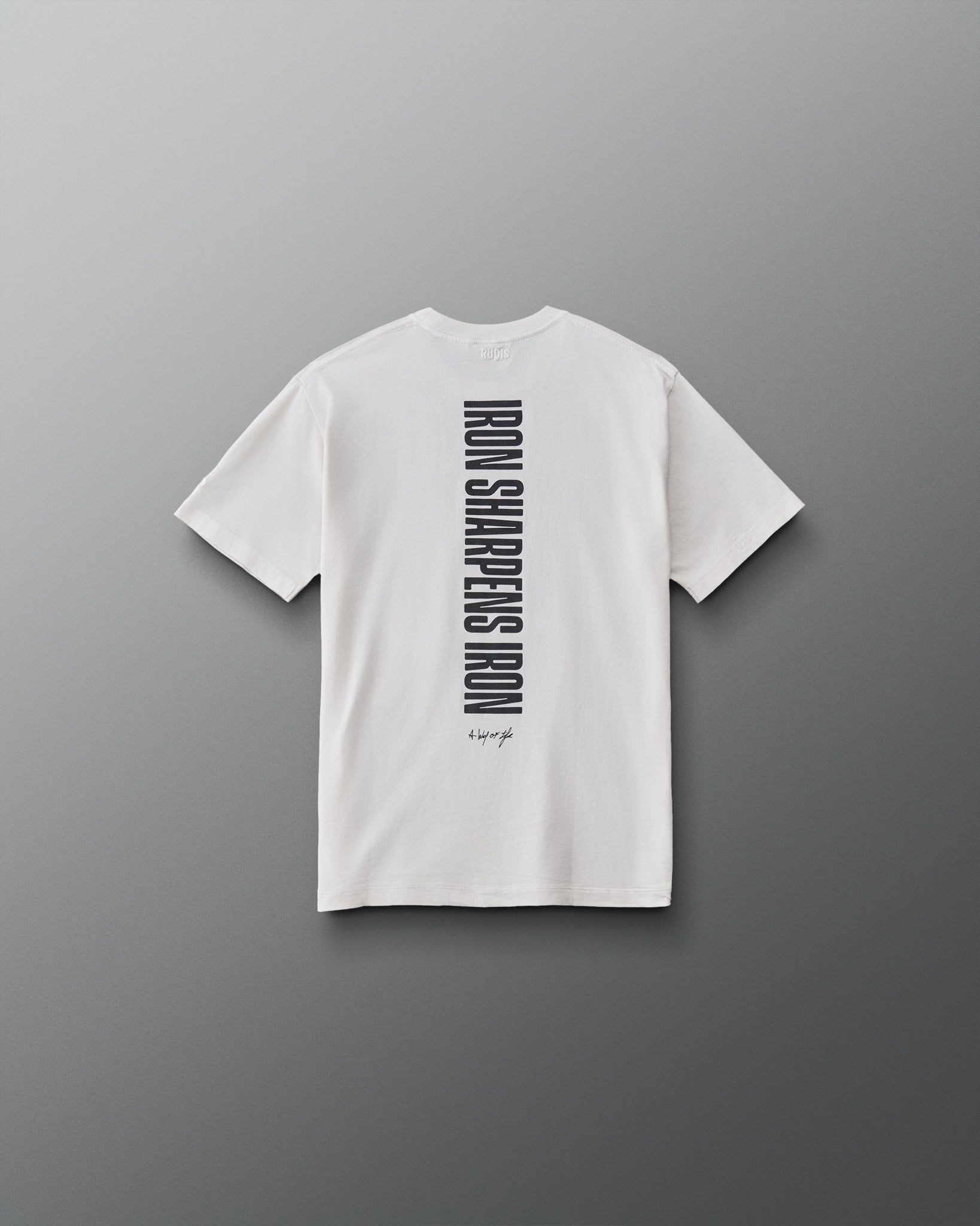 Back view of the RUDIS Iron Sharpens Iron Youth Classic Cotton T-Shirt in Washed Lunar featuring a vertical black Iron Sharpens Iron graphic and A Way of Life signature.