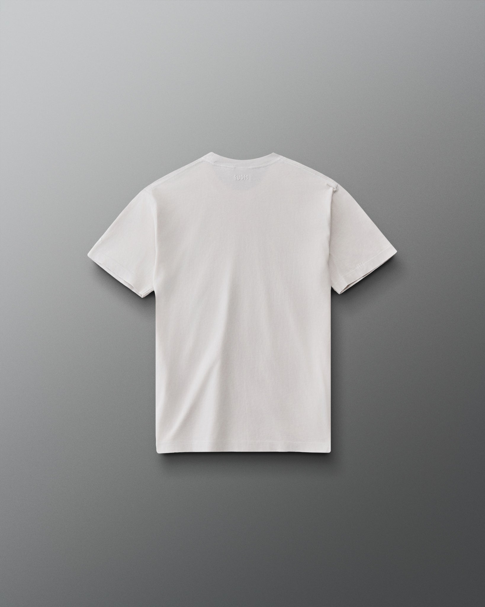 RUDIS Tilted Hex Youth Classic Cotton T-Shirt in Washed Lunar, back view showing a clean off-white design with subtle RUDIS branding below the collar.