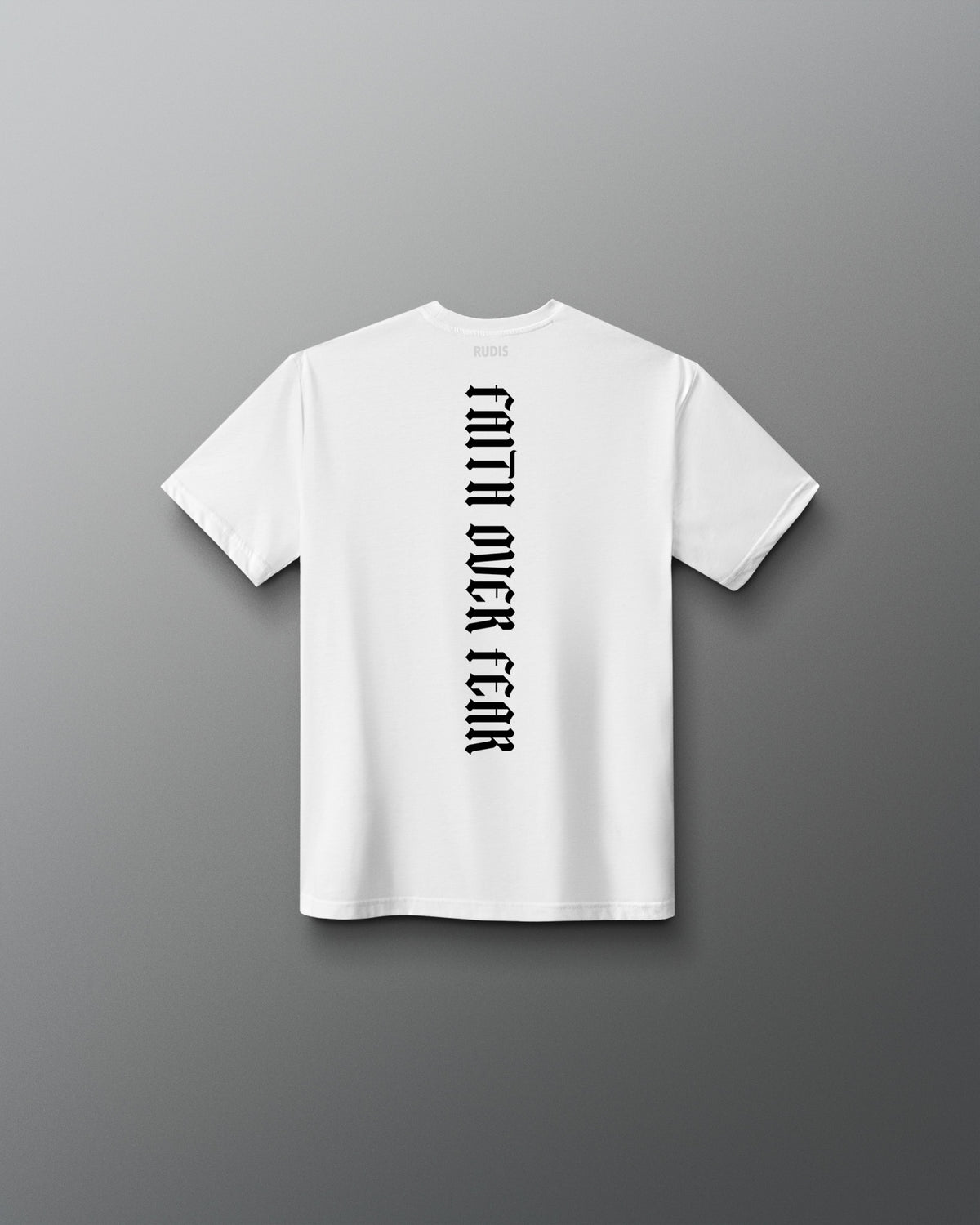 Back of the white RUDIS Cross Youth Elite Super Soft T-Shirt featuring vertical black “Faith Over Fear” lettering and RUDIS neck branding.