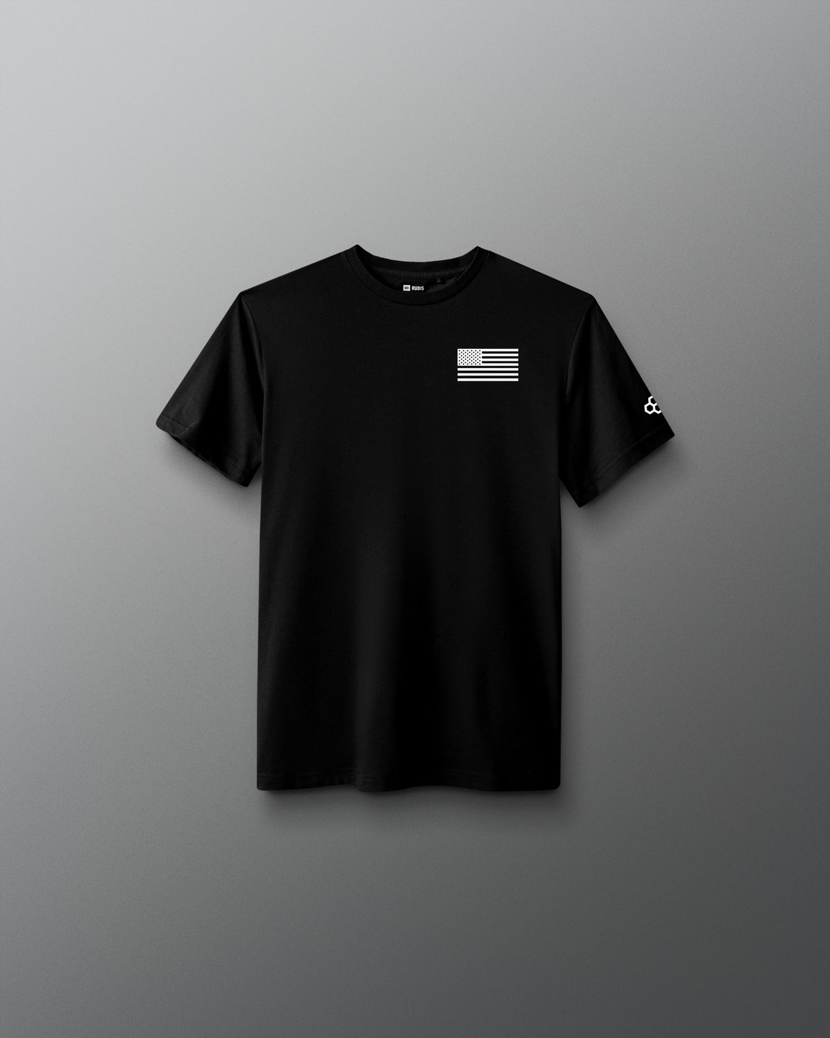 Youth black RUDIS Core Flag Elite Super Soft T-Shirt shown from the front, featuring a white American flag graphic on the left chest and contrasting RUDIS mark on the sleeve.