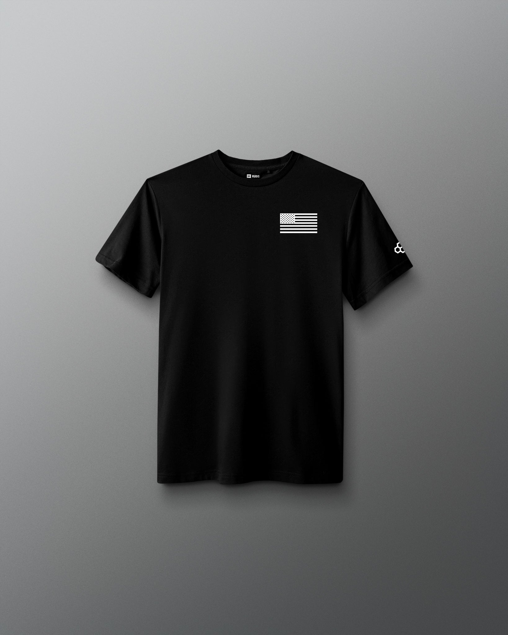 Youth black RUDIS Core Flag Elite Super Soft T-Shirt shown from the front, featuring a white American flag graphic on the left chest and contrasting RUDIS mark on the sleeve.