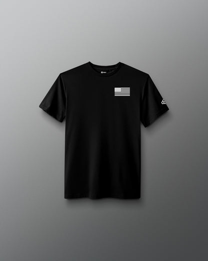 Youth black RUDIS Core Flag Elite Super Soft T-Shirt shown from the front, featuring a white American flag graphic on the left chest and contrasting RUDIS mark on the sleeve.