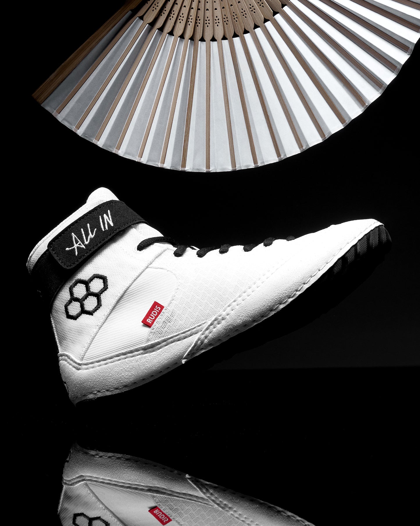 White wrestling shoe with 'All In' branding on a black background