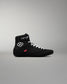 Black wrestling shoe with white laces on a gray background