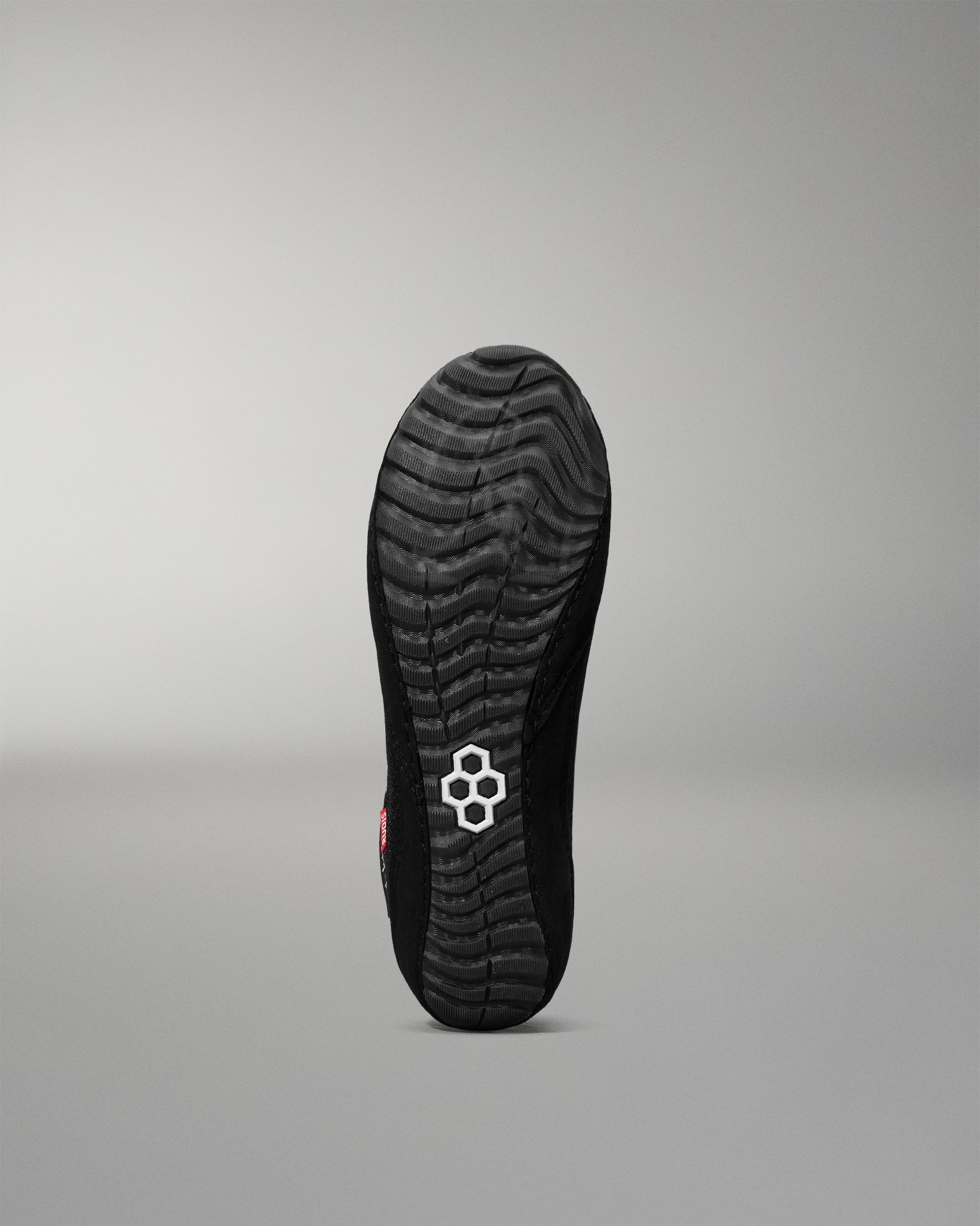 Black wrestling shoe sole with a brand logo on a gray background