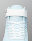 Light blue wrestling shoe with white laces on a gray background