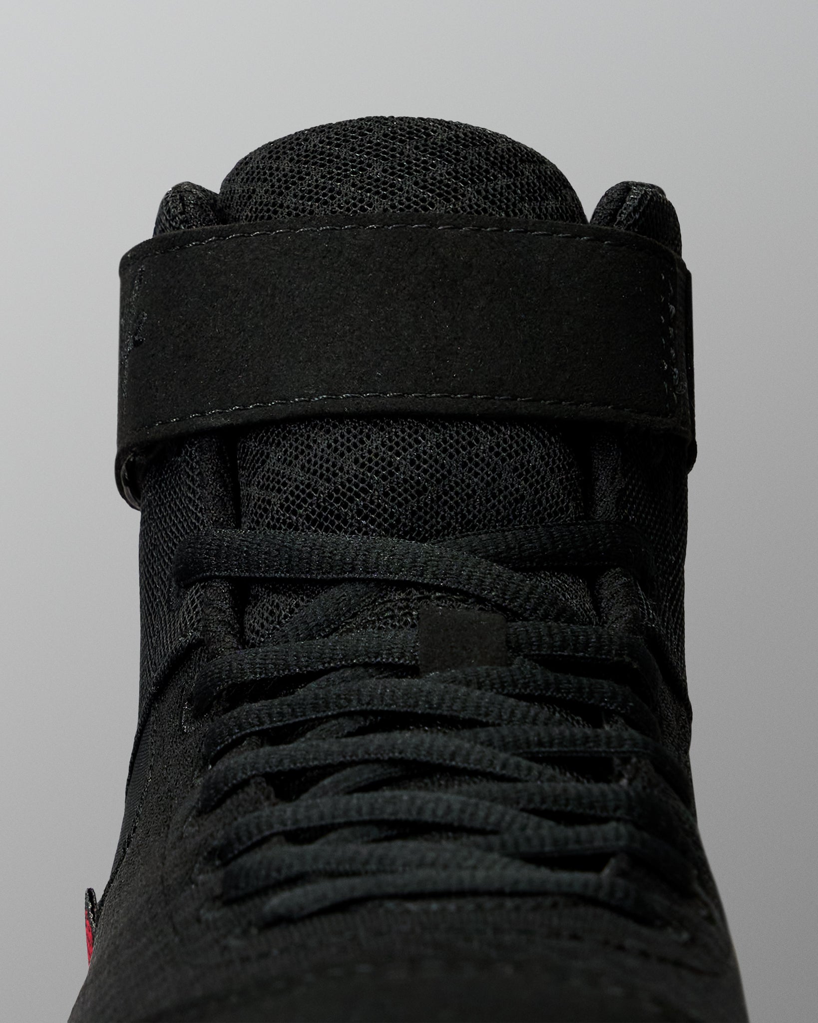 Close-up of the RUDIS Samurai Speed Youth Wabi-Sabi wrestling shoe, showing black laces, textured mesh tongue, and wide ankle strap with stitched detailing.