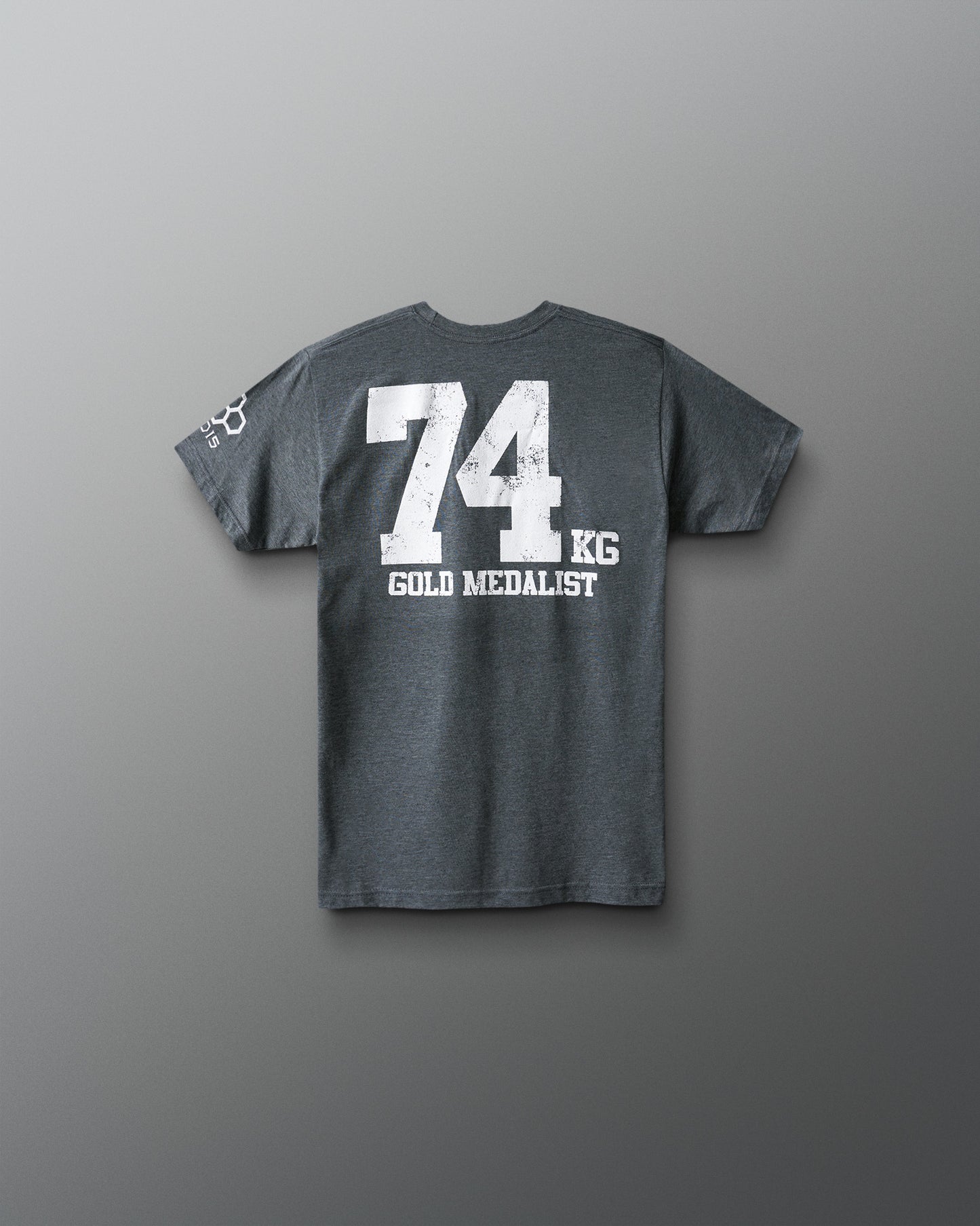 Gray t-shirt with '74 KG GOLD MEDALIST' text on the back against a gray background
