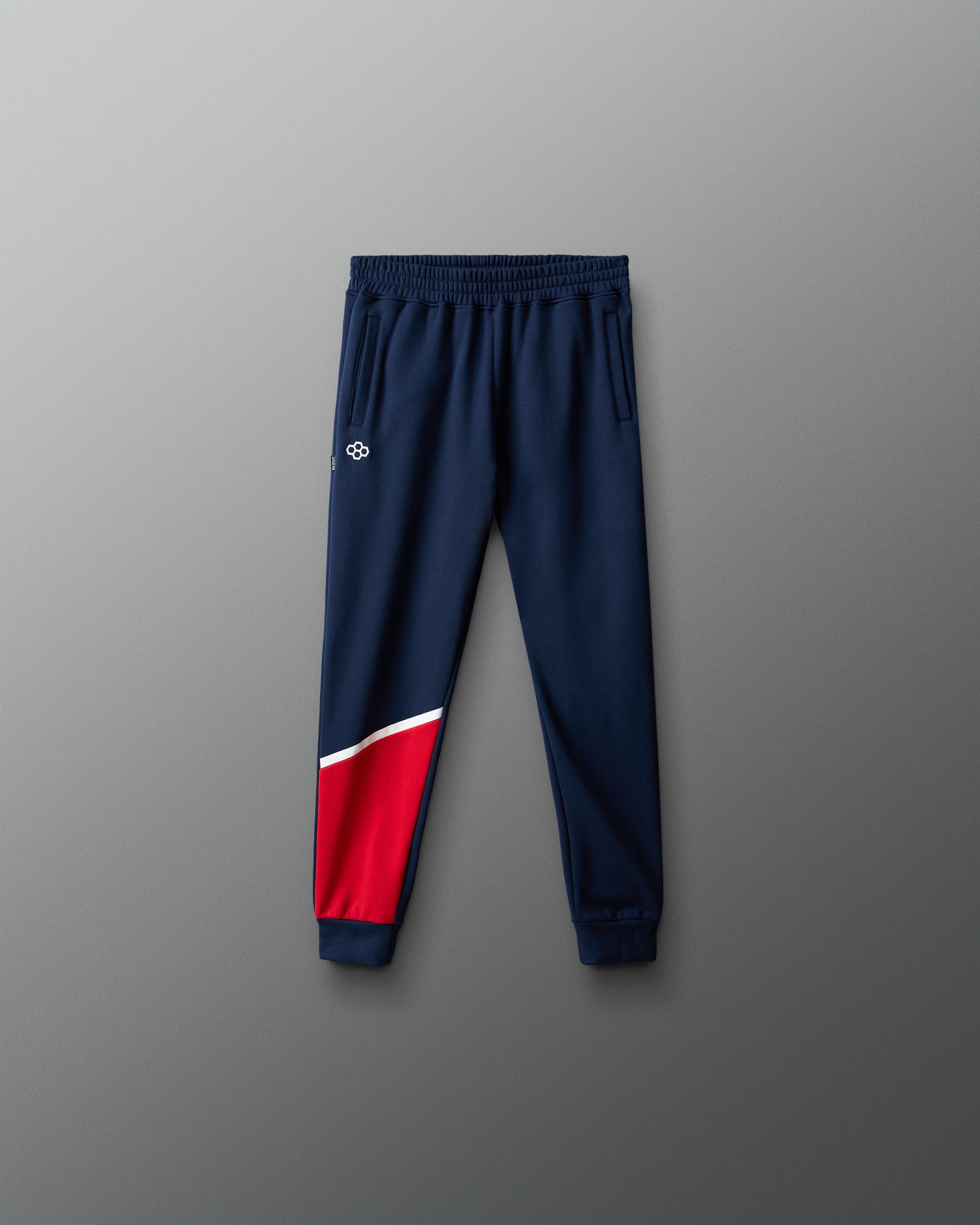 Navy jogger pants with a red section on a gray background