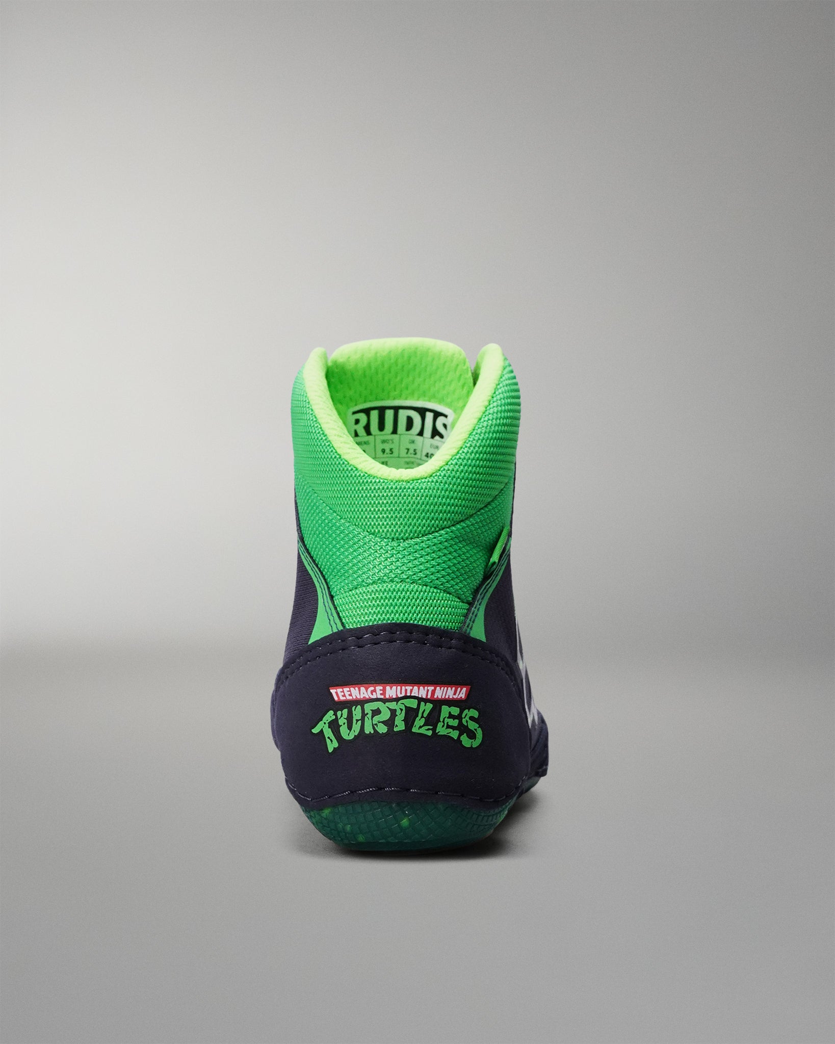 Green and navy Wrestling shoe with 'Rudis' branding on a gray background