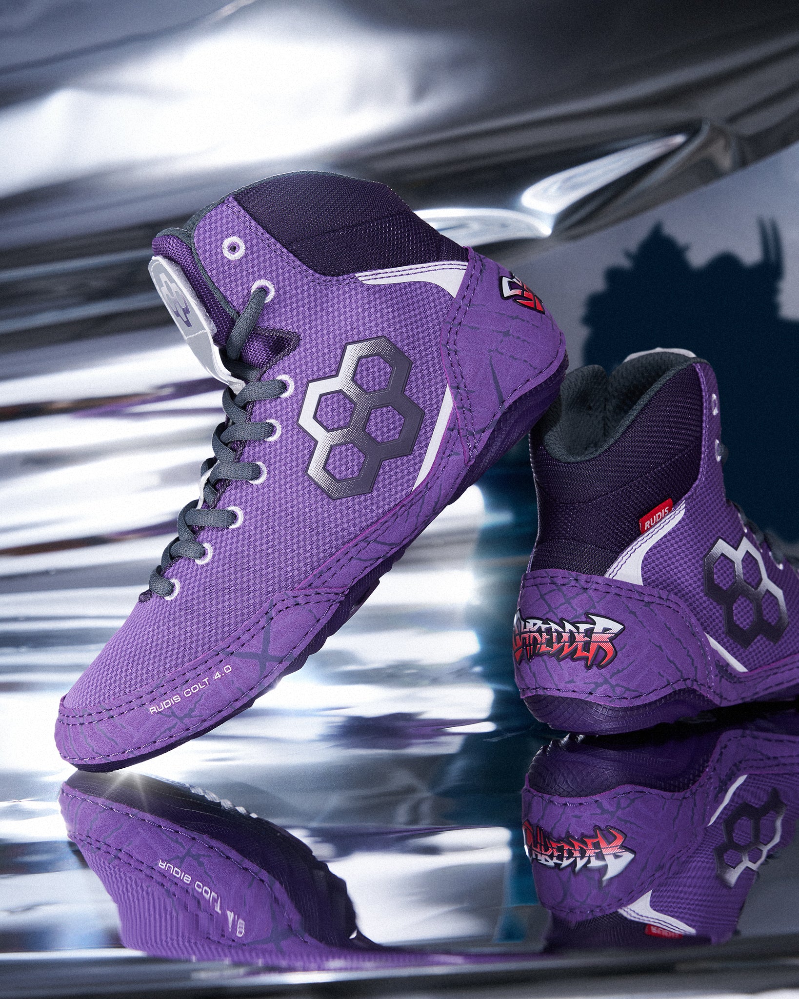 Youth RUDIS Colt 4.0 Shredder wrestling shoes in purple displayed on a reflective metallic surface, highlighting the lightweight high-top design, custom Shredder graphics, and TMNT-inspired details.