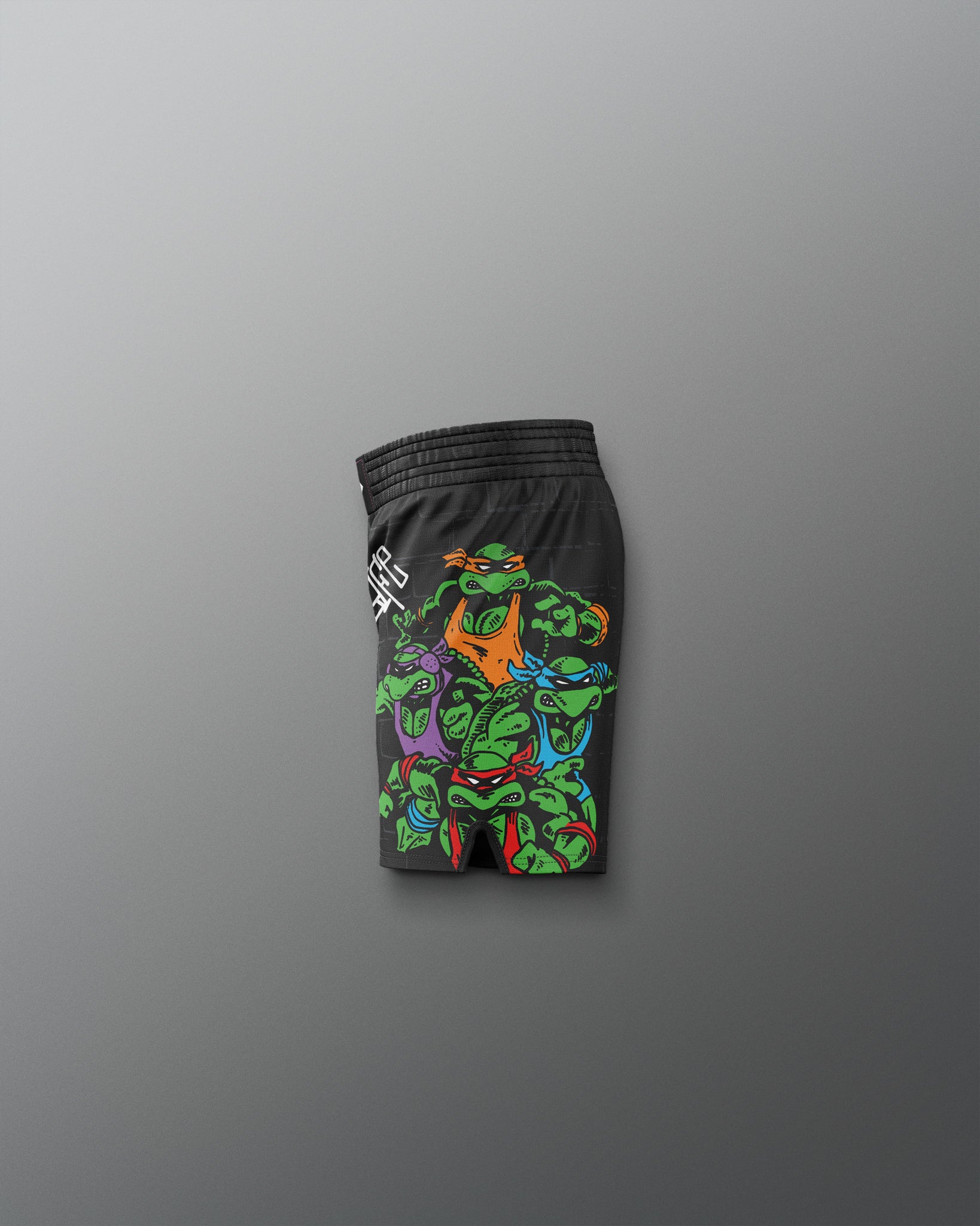 Black shorts with colorful graphic design on a gray background. TMNT. Teenage Mutant Ninja Turtle