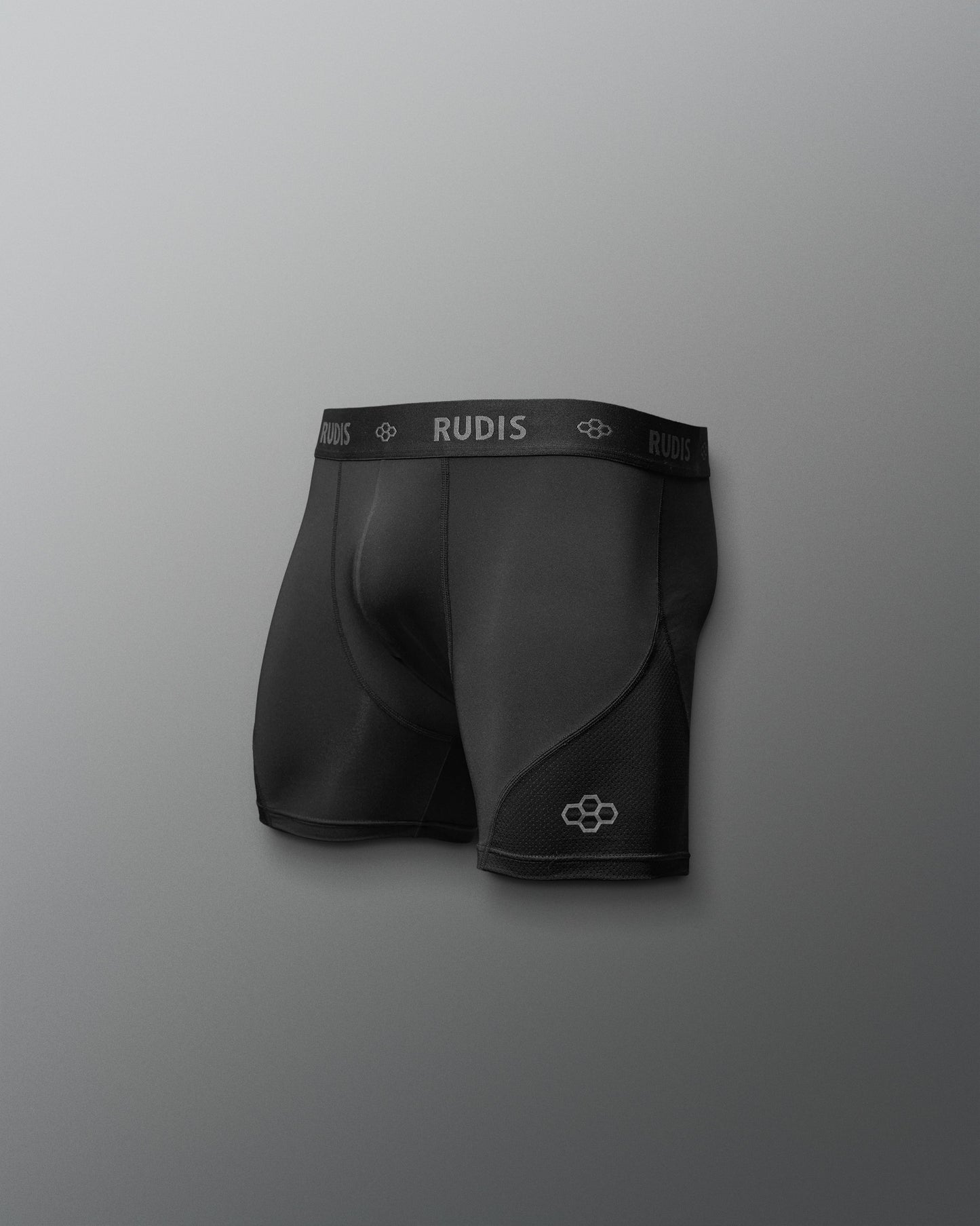 Black athletic shorts with 'RUDIS' branding on a gray background