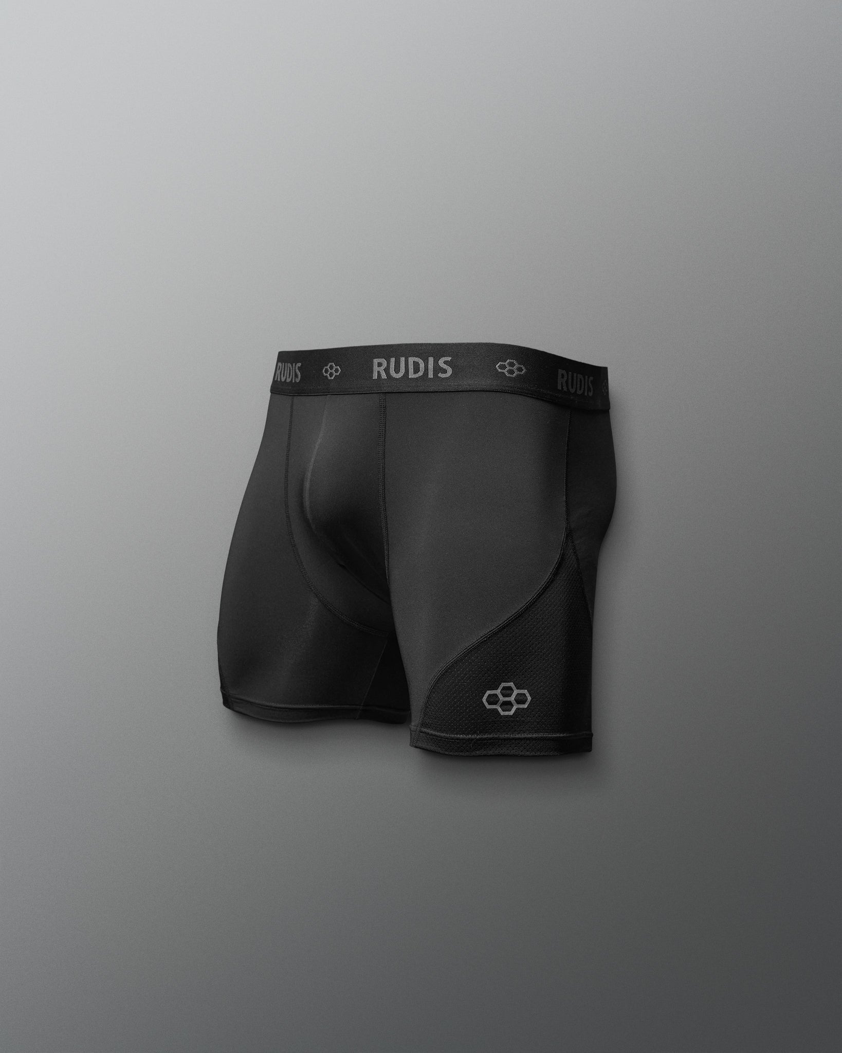 Black athletic shorts with 'RUDIS' branding on a gray background