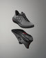 Gray athletic shoe with black sole on a gray background