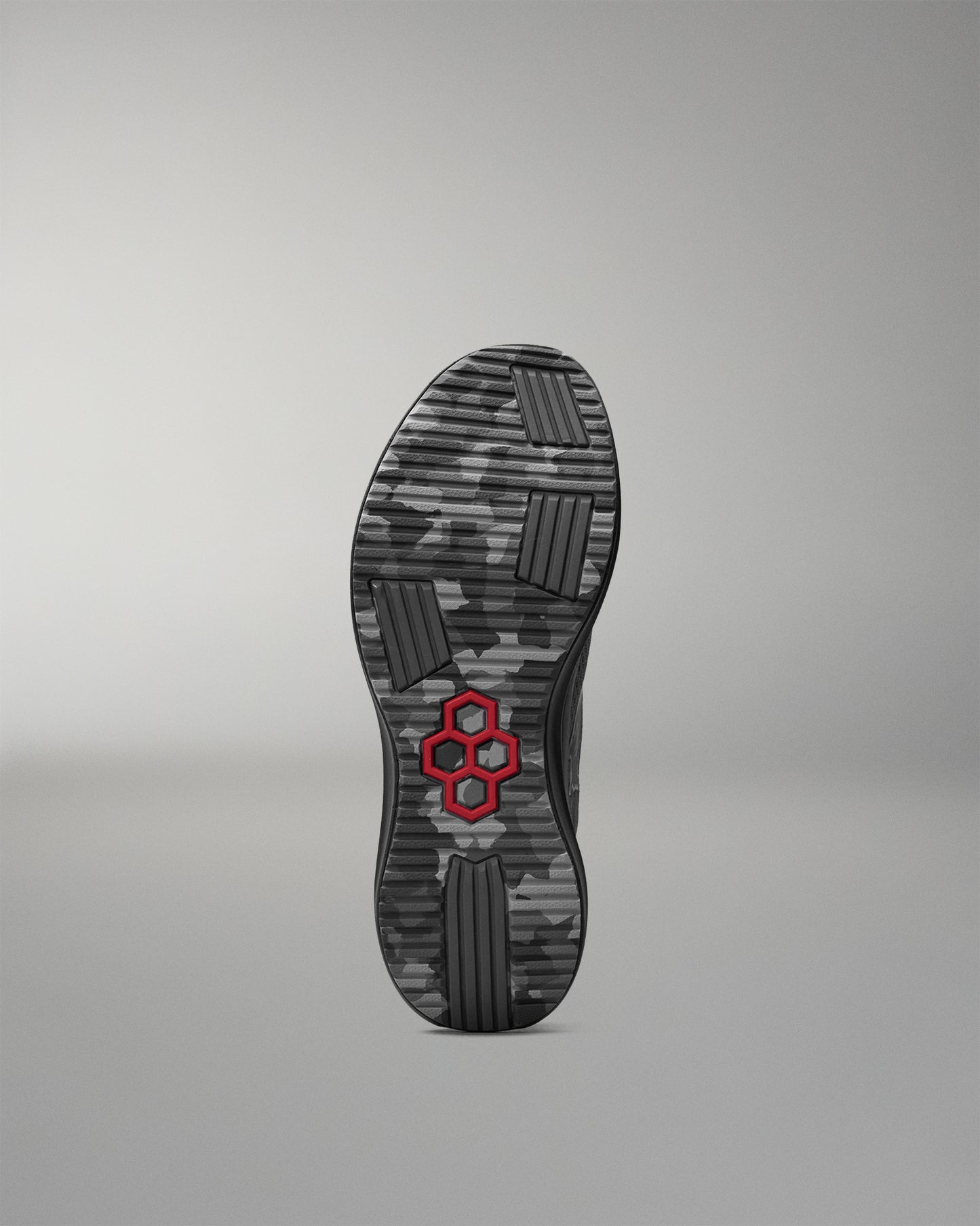 Black shoe sole with a red hexagonal logo on a gray background