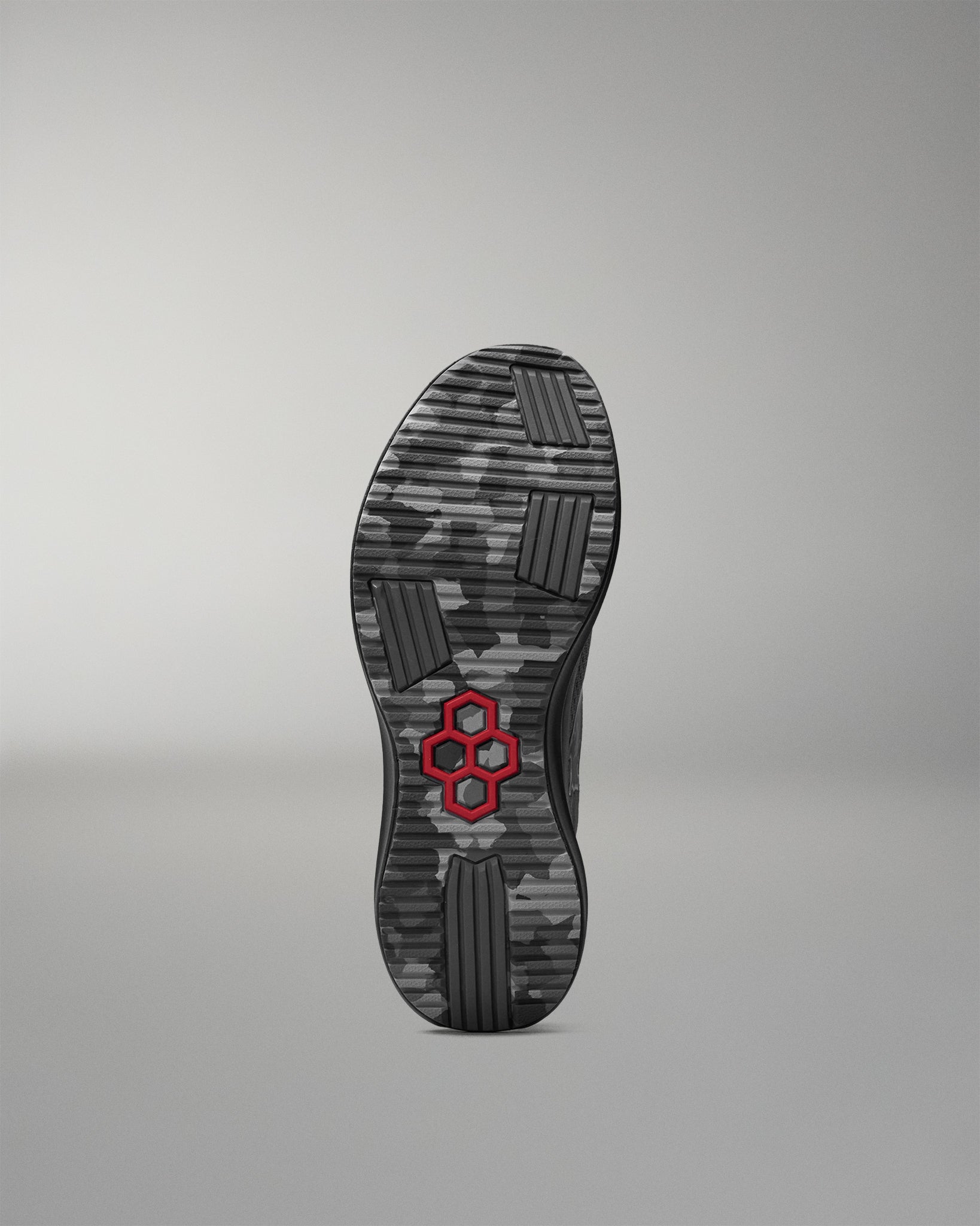 Black shoe sole with a red hexagonal logo on a gray background