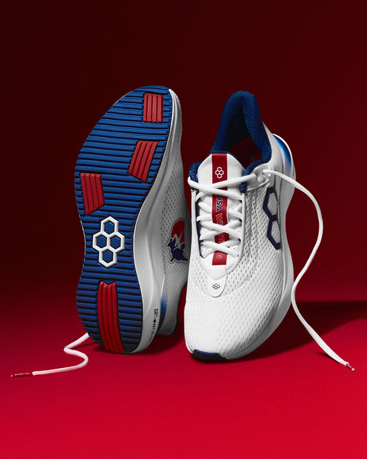 White running shoes with blue and red accents on a red background