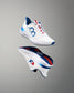 White running shoe with blue and red accents on a gray background