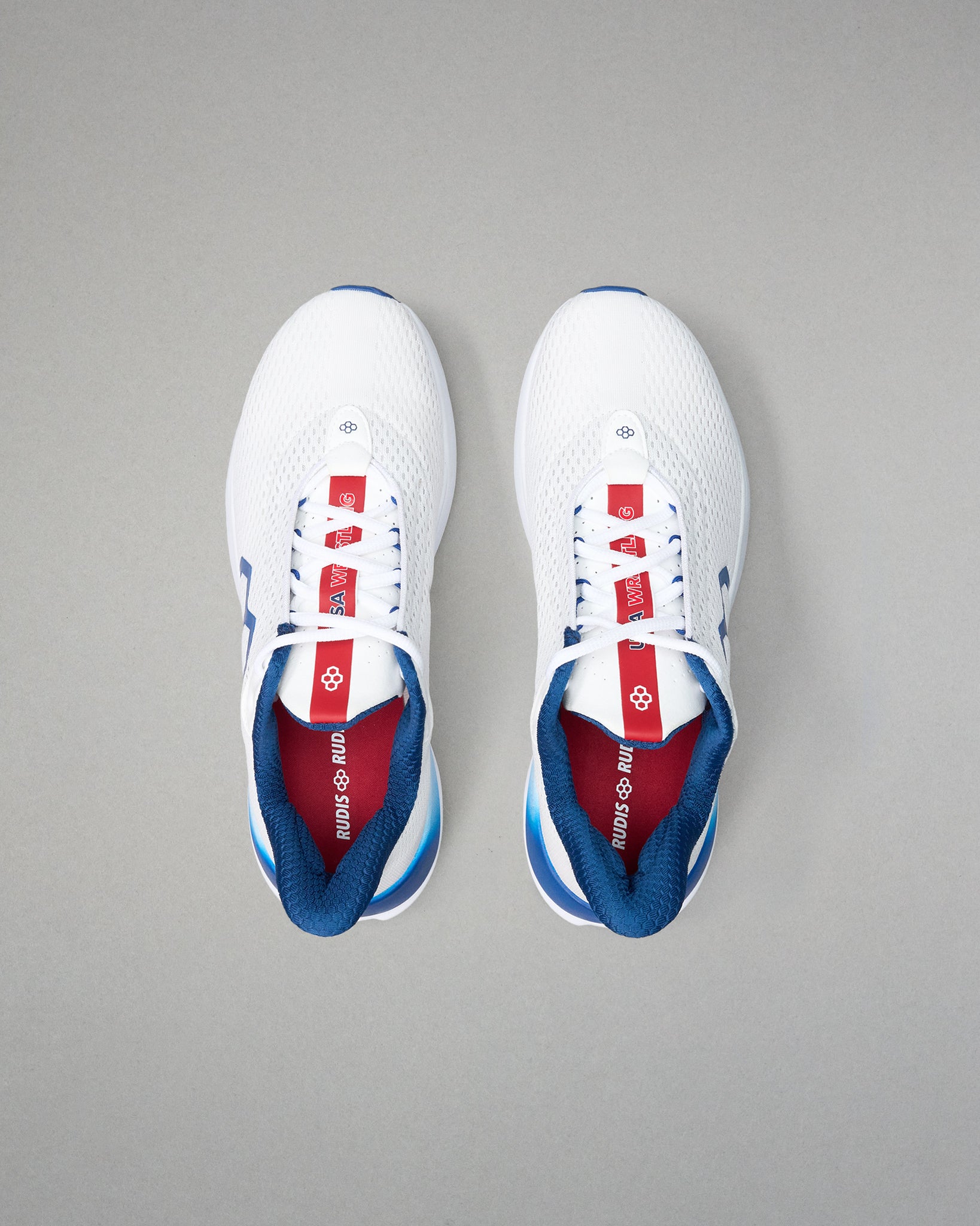 White sneakers with blue and red accents on a gray background