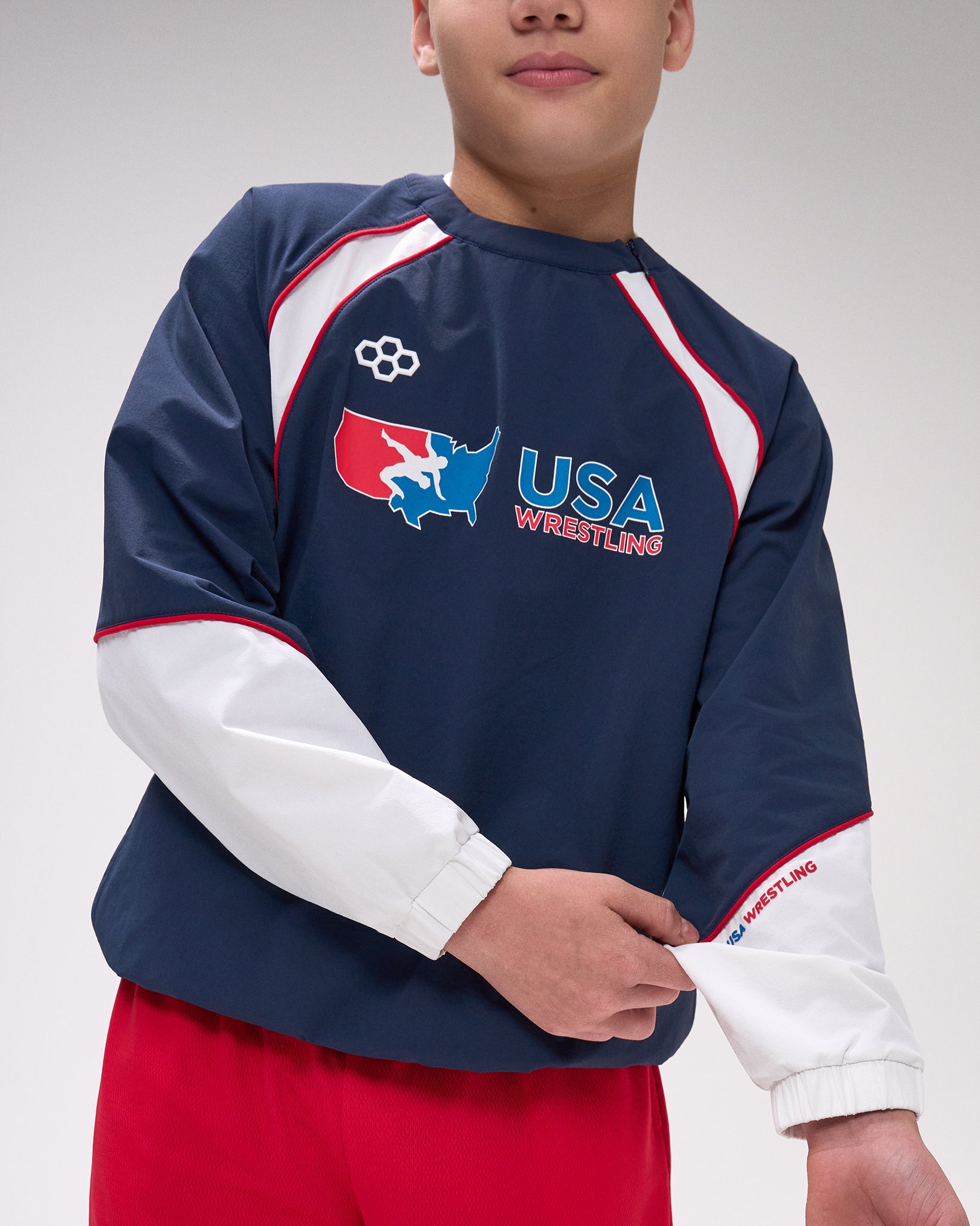 Person wearing a navy blue USA Wrestling sweatshirt with red and white accents on a plain background