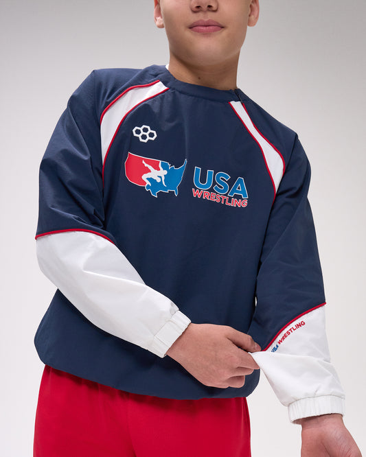 Person wearing a navy blue USA Wrestling sweatshirt with red and white accents on a plain background