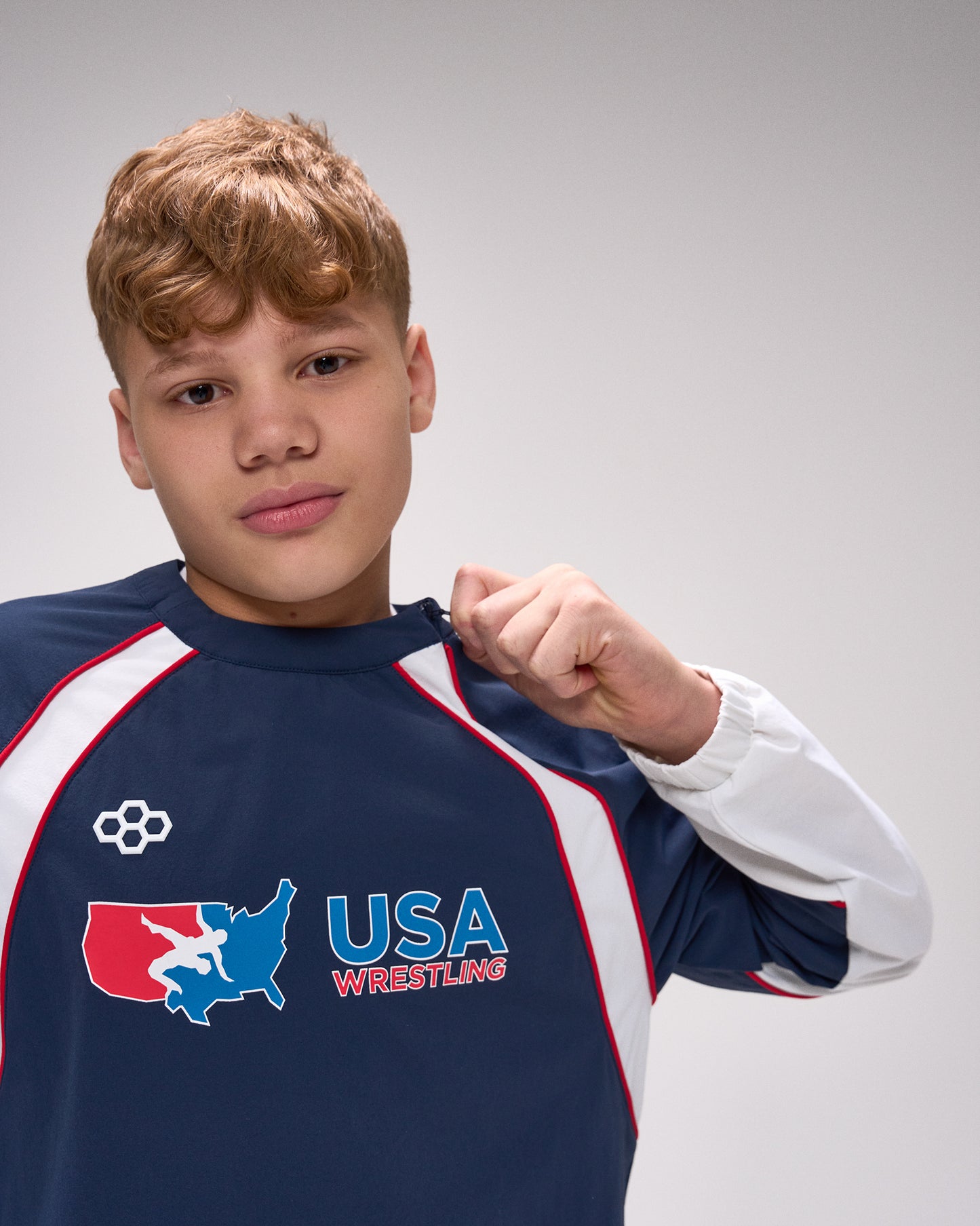 Person wearing a USA Wrestling shirt on a gray background
