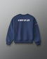 A navy blue crewneck sweatshirt shown from the back, featuring the phrase 'A WAY OF LIFE' printed in bold white capital letters across the upper back. The sweatshirt is displayed on a clean, dark gray gradient background.