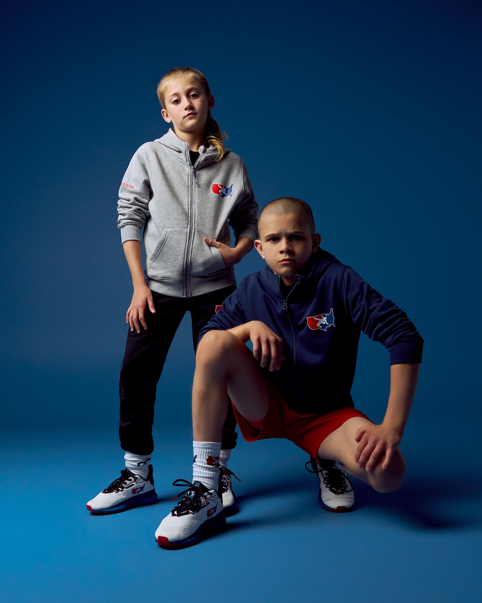 Two children wearing matching outfits with a logo on a blue background