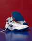 White and blue wrestling shoe with a red background