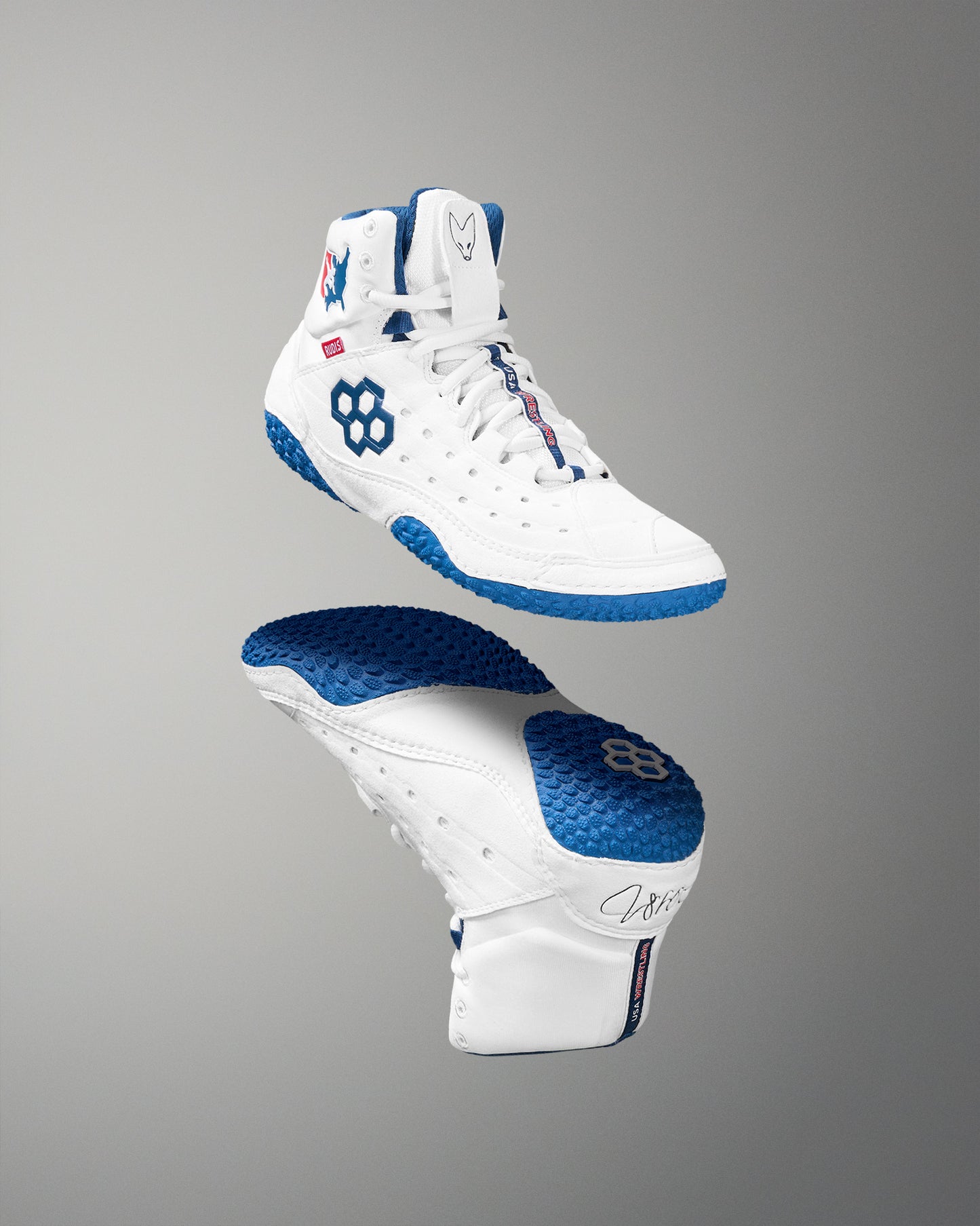 White and blue wrestling shoes on a gray background