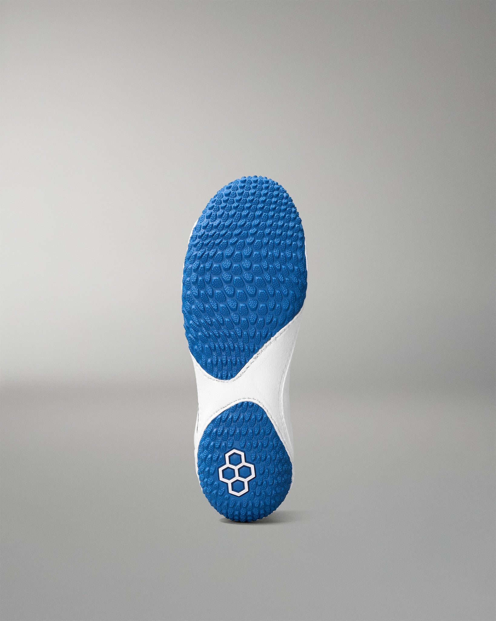 Blue and white sole of a wrestling shoe on a gray background