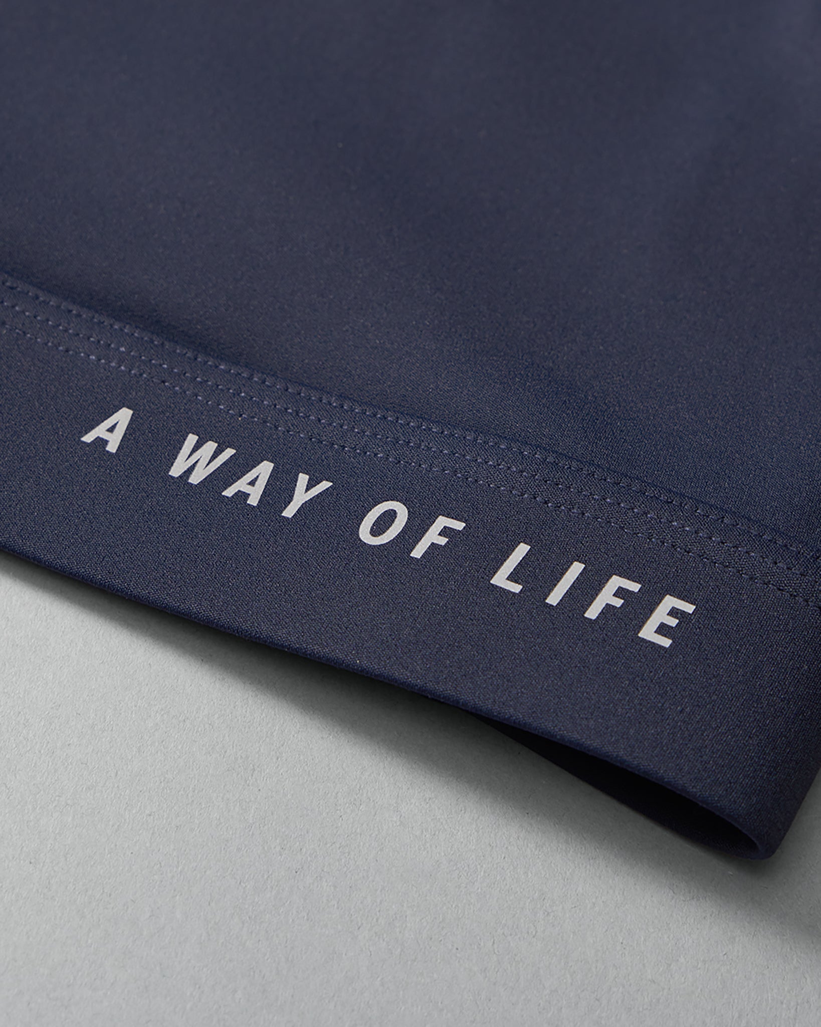 Navy blue fabric with 'A Way of Life' text on a gray background