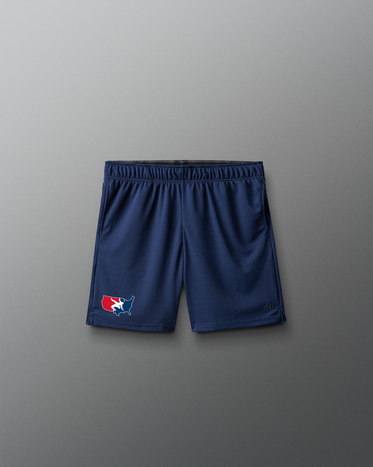 A pair of navy blue athletic shorts with an elastic waistband, featuring a small red, white, and blue logo on the left leg, displayed against a neutral gray background.
