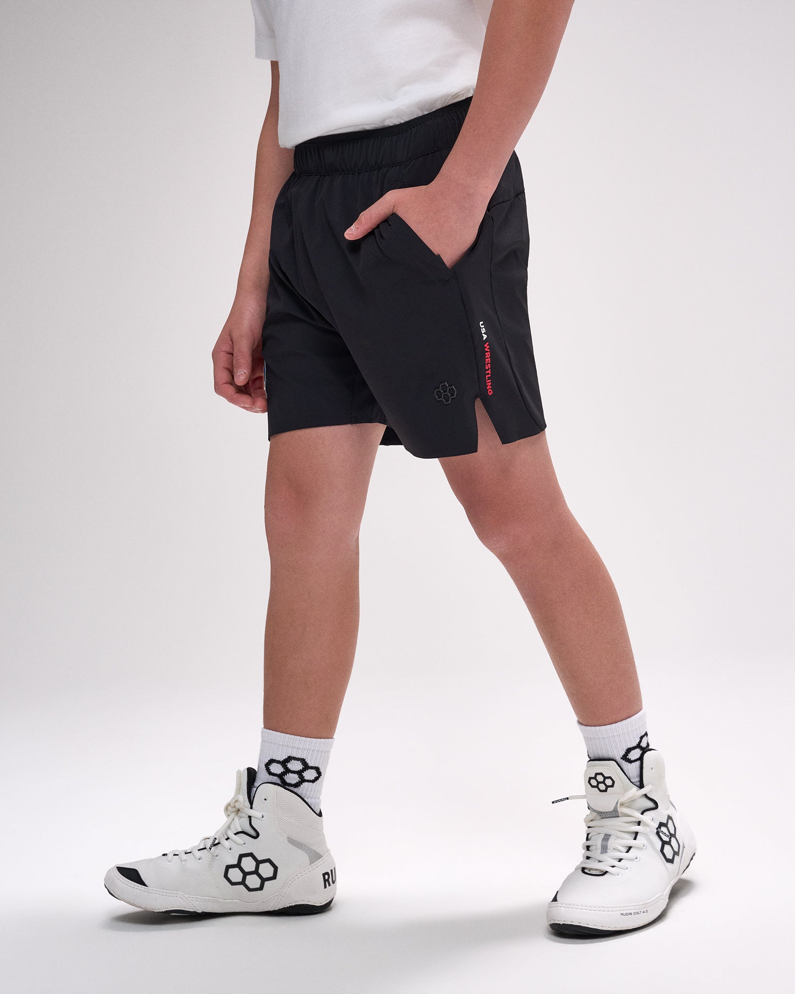 Person wearing black shorts with a red zipper on a white background