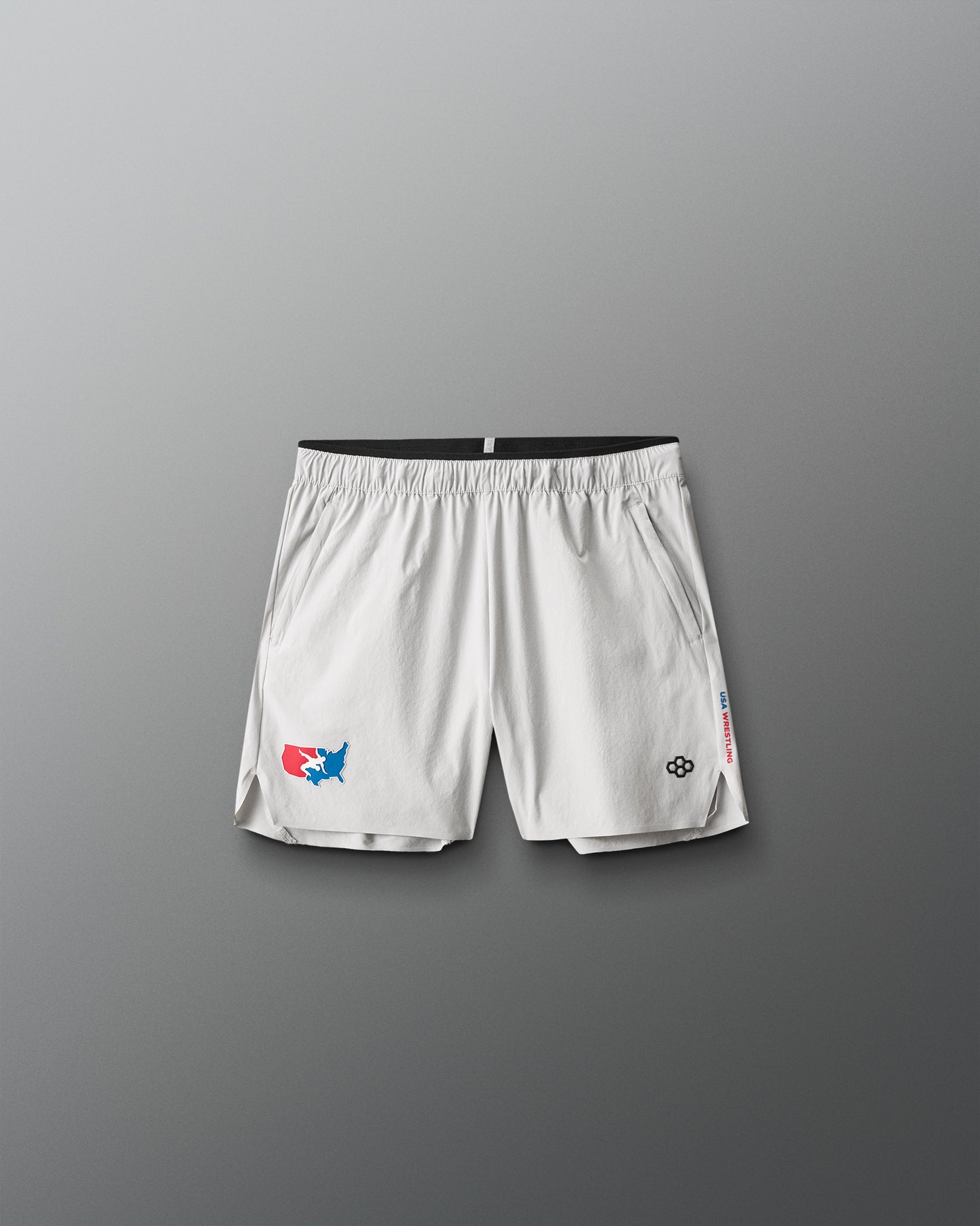 White athletic shorts with USA Wrestling and RUDIS  logos on a gray background