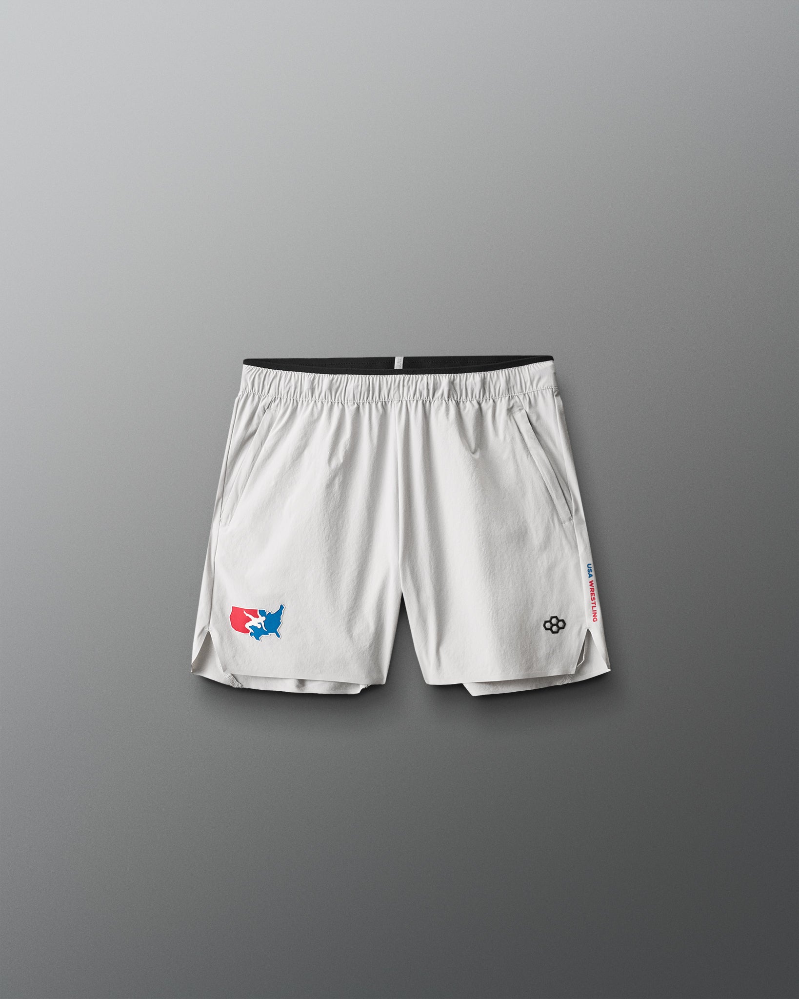 White athletic shorts with USA Wrestling and RUDIS  logos on a gray background