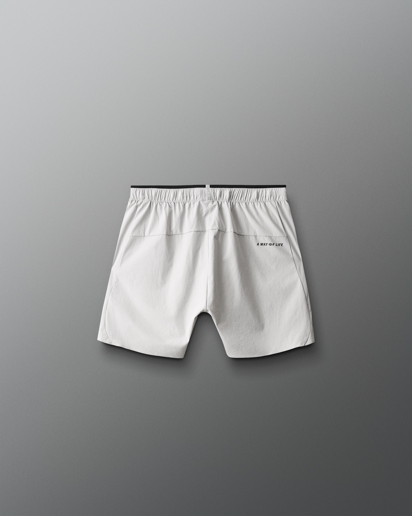 White shorts with a brand logo on a gray background