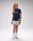 Young girl wearing a USA Wrestling t-shirt and shorts on a gray background