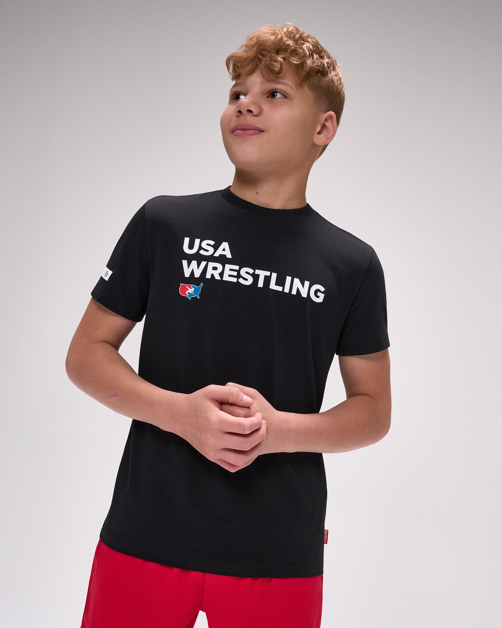 Person wearing a black 'USA Wrestling' t-shirt on a gray background