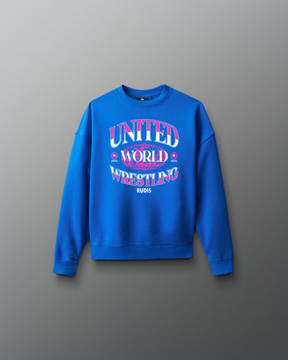 Youth royal blue RUDIS UWW Globe Relaxed Comfort Fleece Crewneck shown from the front, featuring a bold pink-and-white “UNITED WORLD WRESTLING” globe graphic across the chest with RUDIS branding below.