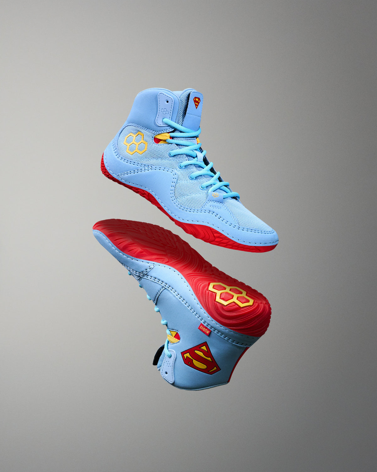 RUDIS JB1 Superman wrestling shoes in light blue with red outsoles, yellow accents and Superman-inspired details.