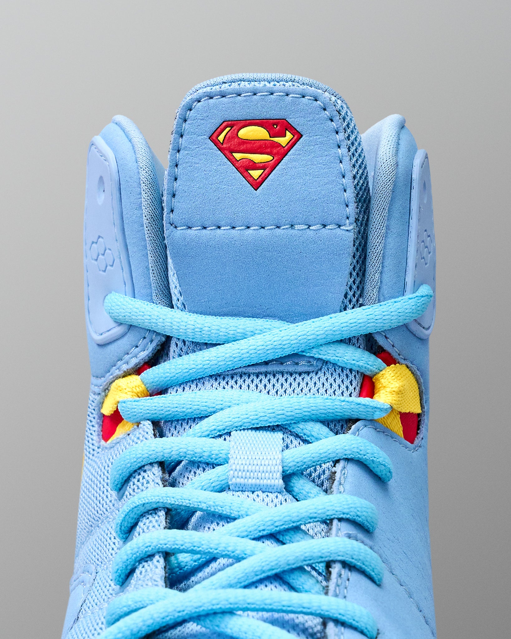 Close-up of RUDIS JB1 Superman wrestling shoe tongue featuring the red and yellow Superman shield above light blue laces.