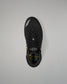 A black athletic wrestling shoe shown from a top-down view against a neutral gray background. The shoe features a black mesh upper, black laces, a black heel counter, and a small yellow accent on the side.