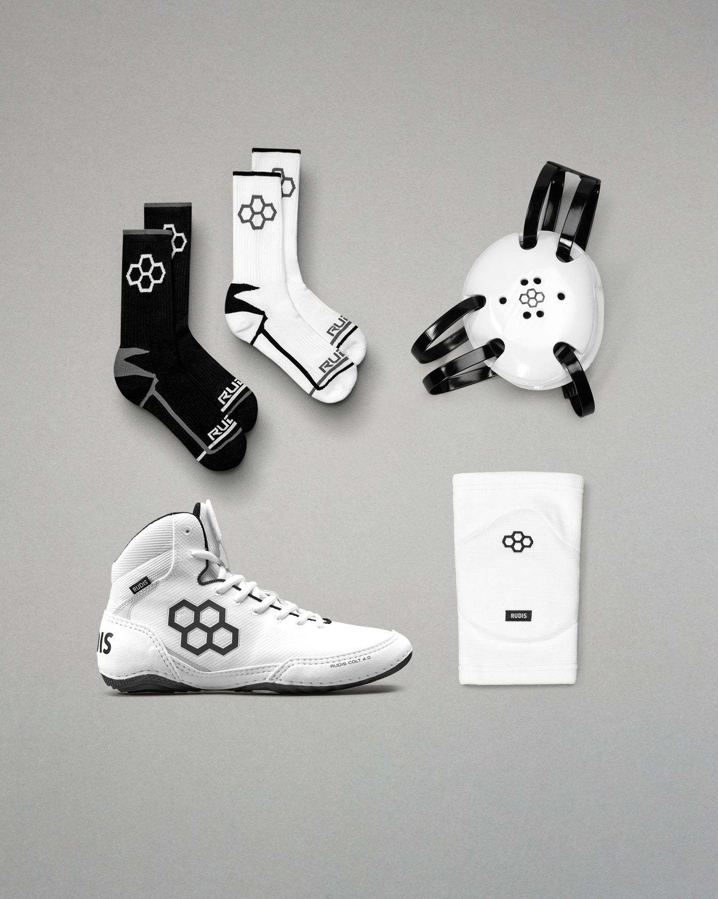 Collection of sports gear including wrestling shoes, socks, and headgear on a gray background